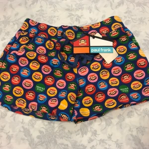 Paul Frank Dam Shorts  - Säljer tre par shorts från Paul Frank. Ett par med färgglatt mönster av apor, ett rött par med vita stjärnor och ett rosa par med applikation. Alla har resårmidja och snörning. 129kr/st . Finns fler färger kvar, samma frakt 