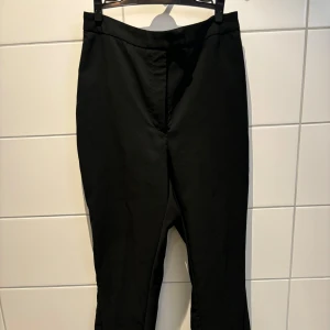 Svarta byxor från NA-KD - Snygga svarta byxor från NA-KD med en stilren design. Byxorna har en rak passform och är perfekta för en chic look. Tillverkade i ett bekvämt material som ger en skön känsla hela dagen.