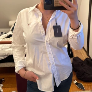 Vit skjorta från Gant - Snygg vit skjorta från Gant med klassisk design och knappar framtill. Perfekt för en stilren look. Passar mig som är en S/M