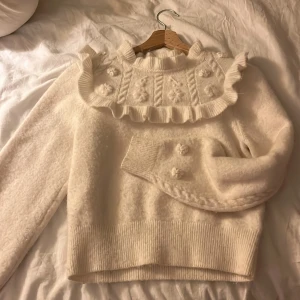 Vit stickad tröja från & Other Stories - Säljer en söt vit stickad tröja från & Other Stories med volangdetaljer och blommönster. I xs. Jag köpte här på Plick men nästan aldrig använt❤️ Pris kan diskuteras 