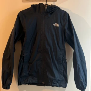 Mörkblå vindjacka  - Vindjacka, sparsamt använd. Alla dragkedjor fungerar och finns dragsnodd längst ner. Säljer då den är för liten. 