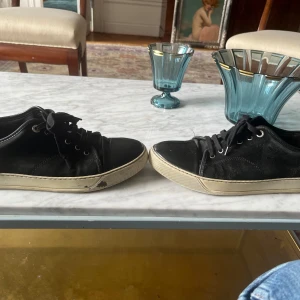 Lanvin toe cap sneaker -  Skicket är helt okej, det finns absolut mycket kvar att ge men har synliga defekter. Den gråa fläcken på sulan är inte permanent och går att tvätta bort. Har bytt ut innersulorna då de gick sönder men sulorna e skönare än originalsulorna i min åsikt