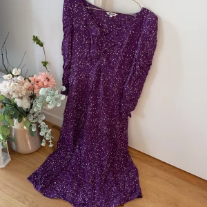 Söt lång klänning  - Jättefint material, perfekt skick i strl S. Färgen är mörk lila 💜 med vita prickar. Fina detaljer på ärm och framsida med små veck. 