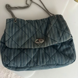 Axelväska - En blå fin väska från Beck Söndergaard du kan hänga över axeln! Den har tappat lite av sin färg o kedjan har rostat lite men det är inget man tänker på!