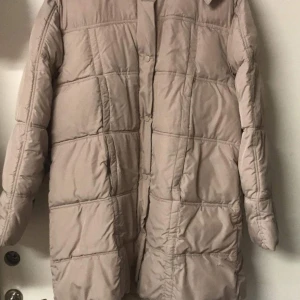 Beige kappa - Varm skön mjuk kappa från Capuccini med avtagbar huva. Storlek uppskattas som en M/L då det inte finns någon lapp i.