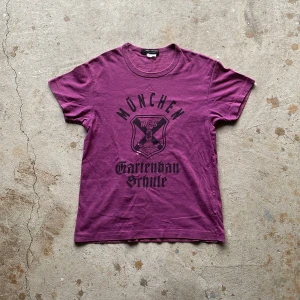 Junya Watanabe T-shirt - Junya Watanabe München crest t-shirt från 2010. Den är i vintage skick, enda flawen är att den har en bleach stain. Passar S/M. Inköpt från Japan