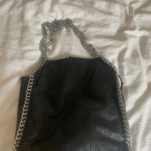 Väska - Säljer denna fina väskan med kedjor. Den är i bra skick och har bra storlek och passform ❤️🥰