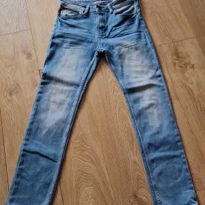 Säljer ett par snygga blå jeans från Hampton Republic i modellen Chase / Slim Fit. De har en dragkedja vid fickan och är i en klassisk blå färg med en lätt tvättad look. Perfekta för både vardag och fest!