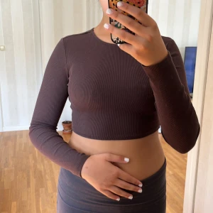 Brun ribbad croppad topp från H&M Divided - Säljer en snygg brun ribbad croppad topp från H&M Divided. Toppen har långa ärmarä. Den är i storlek XXS och passar XS eller S. Perfekt för höst och vår!