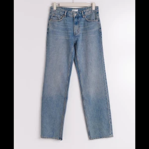 Low Straight Tall Jeans - Säljer ett par snygga low straight tall jeans i en klassisk blå färg. De har en rak passform och är perfekta för en avslappnad stil. Jeansen är tillverkade i ett slitstarkt denim-material och har en låg midja. Perfekta för vardagsbruk! Köpt för 499kr från Ginatricot. Säljer för endast 150kr!