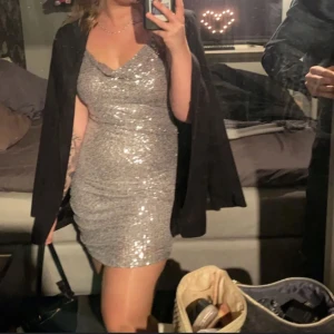 TILL RONJA❗️ - Säljer en superfin glittrig silverklänning som verkligen fångar ljuset! Den är tight och har en snygg drapering framtill. Perfekt för fest eller nyår! Klänningen är ärmlös med smala axelband och en öppen rygg. Den är i nyskick och redo för att bli din nya favorit i garderoben. ✨