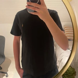 Svart t-shirt från Ralph Lauren - Säljer en svart t-shirt från Ralph Lauren i c slim fit. Perfekt för en stilren och enkel look. Passar både till vardags och fest! Jag som har Storlek S passar den mig perfekt. (Lite stor) så möjligtvis M också. Finns på zalando just nu för 719kr.