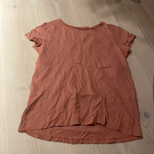 Rostfärgad t-shirt från H&M - Säljer en enkel och bekväm rostfärgad t-shirt från H&M i ekologisk bomull. Perfekt för vardagsbruk med sin avslappnade passform och korta ärmar. T-shirten är i bra skick men något skrynklig. Passar perfekt till jeans eller shorts för en casual look.