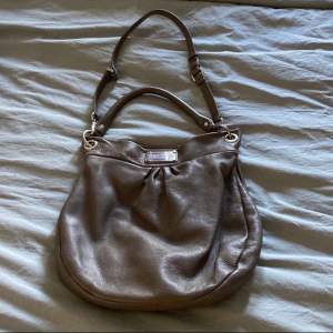 Marc jacobs hobo bag. Beige/grå färg med silverdetaljer. Lite sliten i lädret på vissa ställen som man kan se på sista bilden annars hur fin som helst!🙌🏻🙌🏻🙏🏻 Pris kan diskuteras!