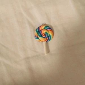 Färgglada smycken i olika former om du vill köpa tyvärr behöver du köpa alla - Säljer ett set med unika smycken! Första är en regnbågsfärgad klubba, perfekt som ett roligt halsbandshänge. De andra två är små flaskor, en i blått och en i lila, som kan användas som charmiga berlocker. Sista är en söt kaninfigur, idealisk för att ge en lekfull touch till din stil. Alla smycken är i nytt skick och redo att användas!