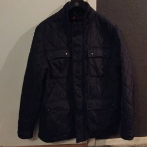 Svart quiltad jacka - Säljer en snygg svart quiltad jacka i mycket bra skick. Den har långa ärmar och praktiska fickor med knappar. Perfekt för höst och vår när du vill hålla stilen och värmen. Passar både till vardags och lite finare tillfällen.