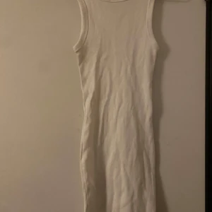 Vit ärmlös klänning - Säljer en stilren vit ärmlös klänning i ett mjukt och bekvämt material. Perfekt för sommardagar eller som en bas i garderoben. Klänningen har en tight passform som framhäver figuren. Passar både till vardags och festliga tillfällen. Använd under 4 tillfällen.