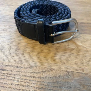 Flätat bälte - Flätat bälte i väldigt bra skick utan slitningar eller liknade, den är i en roligt fet färg svart och marinblå,   Skriv vid minsta fråga eller fundering🔥👍