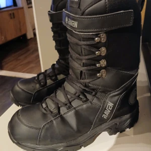 Svarta skoterkängor från Raven - Säljer ett par robusta svarta boots från Raven i storlek 46. De är gjorda av PU-läder med en innerfoder av TPU-membran, vilket gör dem både vattentäta och andningsbara. Perfekta för vintern med snörning och en hög design för extra stöd. Lättvikt som gör dem lätta att gå i. Nypris 1799