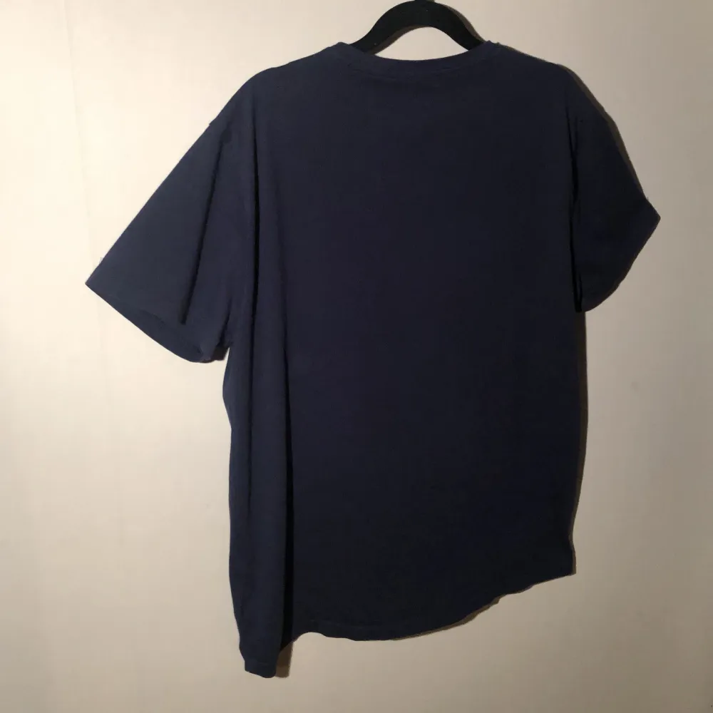 Ralph Lauren mörkblå t-shirt i mjuk bomull med V-ringad. Klassisk passform och stilren design. Perfekt för både vardag och avslappnade tillfällen – ett tidlöst basplagg.Den har också inga hål eller fläckar. Jag kan diskutera priset.. T-paidat.