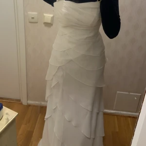 Vit klänning - Säljer en elegant vit klänning med volangdetaljer. Perfekt för bröllop/ bal/ studenten osv . Klänningen har en smickrande passform. Den är i mycket bra skick och ser bättre irl med tagg kvar. Nypris 4500. Skriv för mer detaljer 