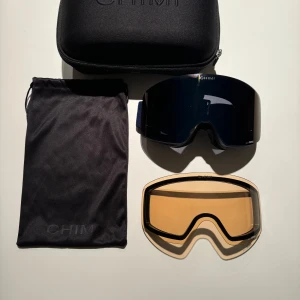 Chimi 01 Skidglasögon   - Chimi 01 skidglasögon i färgen mörkblå. Använda ett fåtal gånger. Allt tillbehör som extrallins, torkduk och fodral och påse till linsen ingår i köpet. Skicket på skidglasögonen är 9 av 10. 