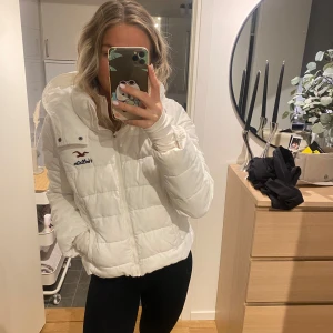 Vit pufferjacka från Hollister - Säljer en vit pufferjacka från Hollister. Den har en dragkedja framtill och en stor huva. Jackan är i mycket bra skick. Det är storlek L men den är ganska liten i storleken för att vara en L.