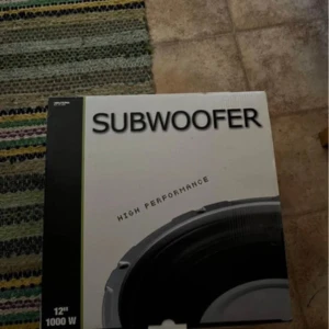 Subwoofer High Performance 12" 1000W - Säljer en kraftfull subwoofer med hög prestanda. Den har en storlek på 12 tum och en effekt på 1000 watt, perfekt för att få riktigt bra basljud. Produkten är ny i kartong och inkluderar installationsmanual.