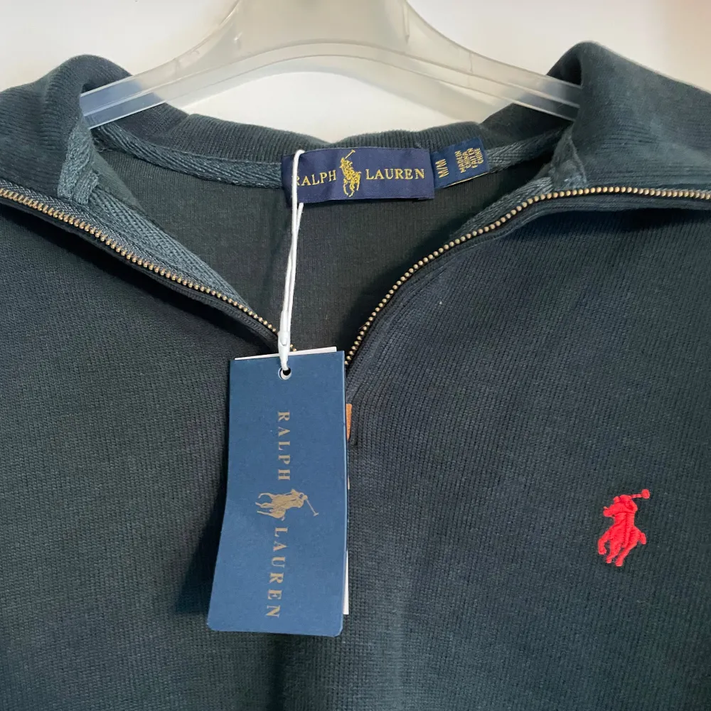 Säljer en snygg mörkgrön tröja från Ralph Lauren i mycket bra skick. Den har en dragkedja vid halsen och det klassiska röda logotypbroderiet på bröstet. Perfekt för både höst och vår. Passar bra till både vardag och lite finare tillfällen.. Tröjor & Koftor.