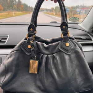 Marc Jacobs väska  - Säljer Marc Jacobs väska i ett svart läder med guld detaljer. Väskan är äkta och pris kan diskuteras💗