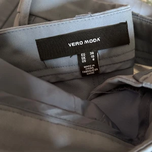 Kostymbyxa från Vero Moda storlek 38 - Snygga näst intill oanvända kostymbyxor från Vero Moda! Dessa kostymbyxor är hög/normal midjade byxor som är raka i benen! Super sköna! Använde dessa byxorna en gång.