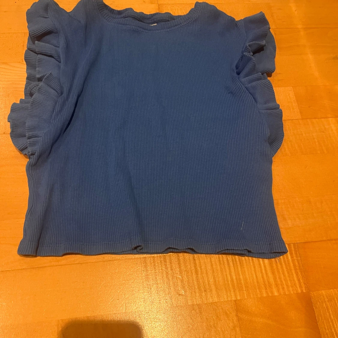 Blå ribbad topp med volangdetaljer