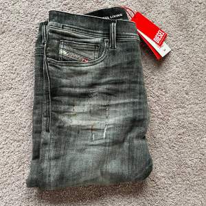 Säljer ett par snygga grå jeans från Diesel i nytt skick alla lappar sitter kvar! De har en cool slitningseffekt och en klassisk femficksdesign! Perfekta för både vardag och fest! Storlek 31w 30l men sitter mer som 32 L! Ny pris är 3500kr mitt pris endast 799kr! Hör av er vid frågor!!