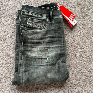 Grå jeans från Diesel - Säljer ett par snygga grå jeans från Diesel i nytt skick alla lappar sitter kvar! De har en cool slitningseffekt och en klassisk femficksdesign! Perfekta för både vardag och fest! Storlek 31w 30l men sitter mer som 32 L! Ny pris är 3500kr mitt pris endast 799kr! Hör av er vid frågor!!