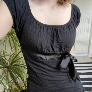 Svart gullig topp 🖤 - En urgullig svart topp med babydoll siluett och rosett där fram 😍Så söt med typ ett par basic jeans eller kjol