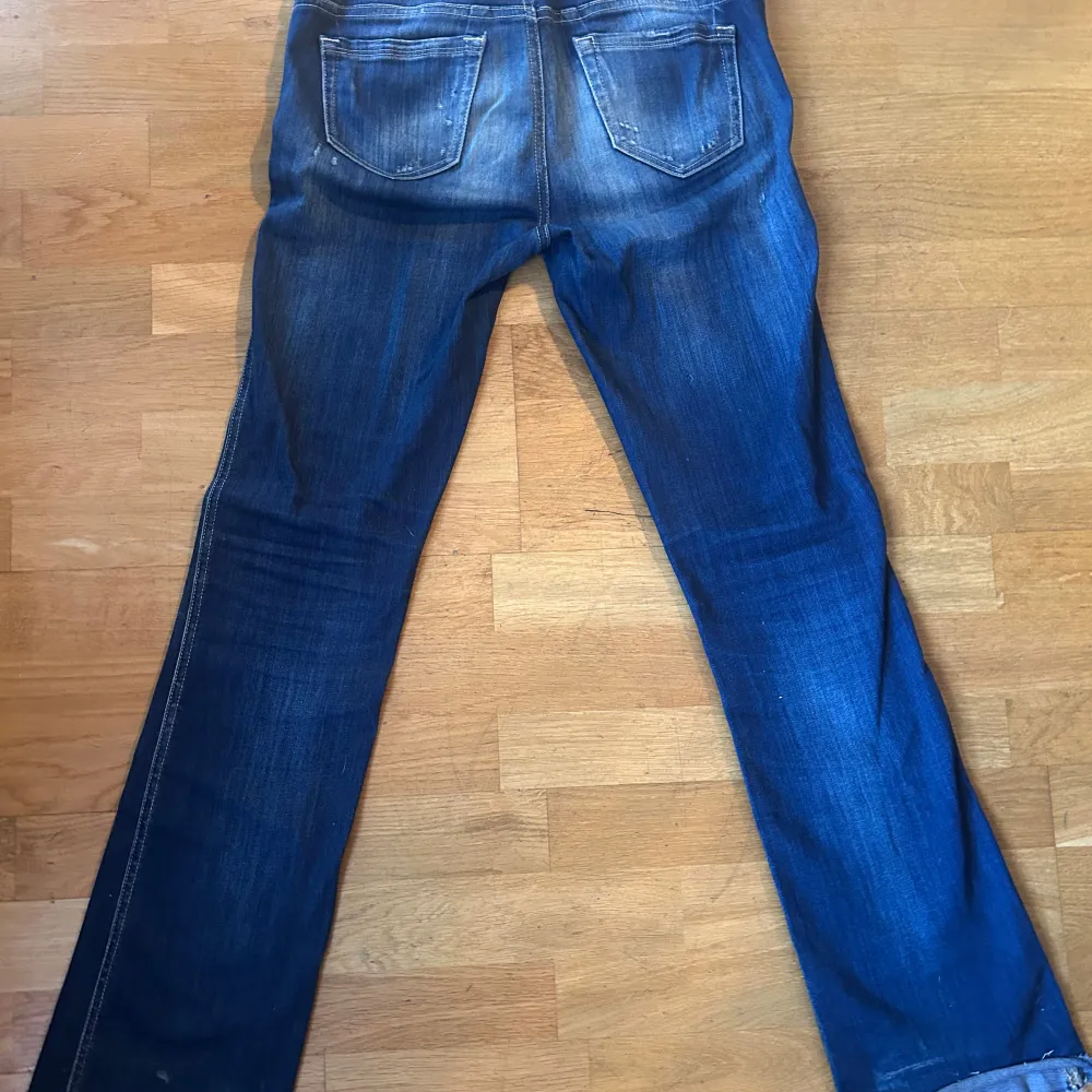 Säljer ett par snygga blå lågmidjade bootcut jeans med coola slitningar.  Perfekta för en avslappnad stil och passar till det mesta. Sköna och trendiga! De är jätte stretchiga så de är lätta att böja sig ner med osv. Skriv till mig för måtten🥰💝💝. Jeans & Byxor.