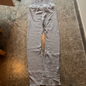 Low waist mjukisbyxor från Gina - Supermysiga grå mjukisbyxor från Gina. Perfekta för chilliga dagar hemma eller en avslappnad dag ute. De är ribbade i midjan för extra komfort och har en enkel design som passar till allt. Materialet är mjukt och skönt, vilket gör dem till ett måste i garderoben!