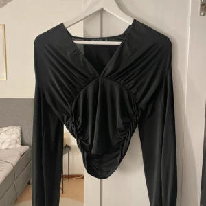 Svart topp - Topp ifrån Nelly, modellen heter ”Plunge neckline top”. Endast använd 1-2 ggr så väldigt fint skick utan defekter☺️