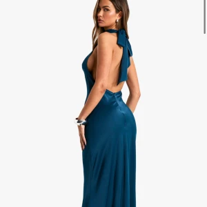 Balklänning Satin  - Elegant blå teal långklänning i satin med en halterneck-design och öppen rygg. Klänningen har en vacker knytning vid nacken och en figurnära passform, Perfekt för speciella tillfällen som balen. Klänningen är helt oanvänd och i perfekt skick! Den är inte skräddarsydd efter mig. 