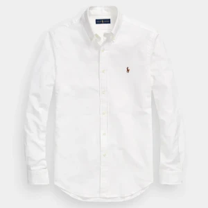 Vit Ralph lauren skjorta - Klassisk vit skjorta från Ralph Lauren. Skjortan har långa ärmar och knappar framtill. Perfekt för en stilren look. Näst intill ny använd fåtal gånger och den passar en storlek S men enligt Ralph Lauren str arton år custom fit. Tveka inte på att skriva vid fler frågor! 