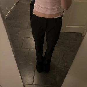 Svarta kostymbyxor - Snygga svarta kostymbyxor med en klassisk passform. Perfekta för en stilren look. Byxorna har en rak design och är midwaist, vilket ger en bekväm och modern känsla.