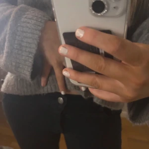 Lågmidjade svarta bootcut jeand  - Snygga svarta jeans med unika vita vingdetaljer på sidorna. Säljer eftersom de är för små! 