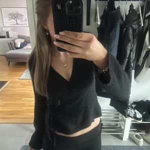 Svart omlottkofta - Säljer min svarta omlottkofta med knytning i midjan från gina. Liten i storleken.