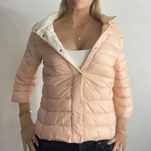 Persikofärgad dunjacka - Jättefin persikofärgad dunjacka med trekvartsärm som liknar Herno jackan, perfekt till våren!! Super snygg men kommer ej till använding💗har även samma jacka i svart och en i ljusblå❣️