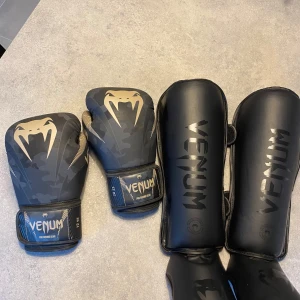 Boxnings handskar, benskydd och shorts (Mma, K1 ,muay thai) - Säljer ett par boxningshandskar och benskydd från Venum som är i fint skick och knappast användna. Shortsen är från Legacy och är i storlek XL. Handskarna är 12 ozare och funkar bra till både sparring, säck eller mitsar. Benskydden är storlek L. Hör av er ifall ni är intresserade eller vill ha fler bilder.  