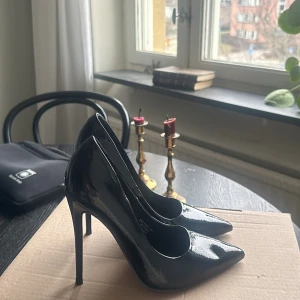 Svarta lackpumps med hög klack - Snygga svarta pumps i lack med hög klack och spetsig tå. Perfekta för en elegant look.