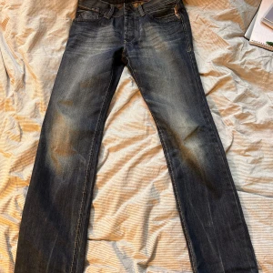 Blå jeans från EDC - Snygga blå jeans från EDC med en klassisk femficksdesign och slitna detaljer. De har en knappgylf och är tillverkade i ett robust denimtyg. Perfekta för en avslappnad stil. Riktigt snygg tvätt på de! W29, L32.