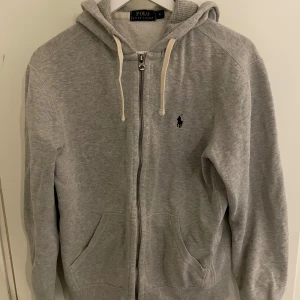 Grå hoodie från Polo Ralph Lauren - Säljer grå hoodie från Ralph Lauren. Använd men väl omhändertagen. Köpt 1 399kr på NK.