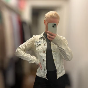 Ljusblå jeansjacka - Säljer en snygg ljusblå jeansjacka med knappar framtill. Jackan har en klassisk design med två bröstfickor och långa ärmar. Perfekt för att ge en cool touch till din outfit!