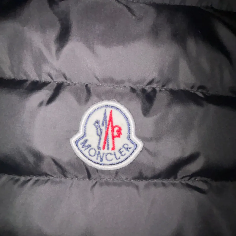 PRISET DISKUTERAS I DM. Säljer en snygg svart dunväst från Moncler med dragkedja och broderad logga på bröstet. Västen har en quiltad design och två praktiska fickor med dragkedjor. Perfekt för kyligare dagar!. Takit.